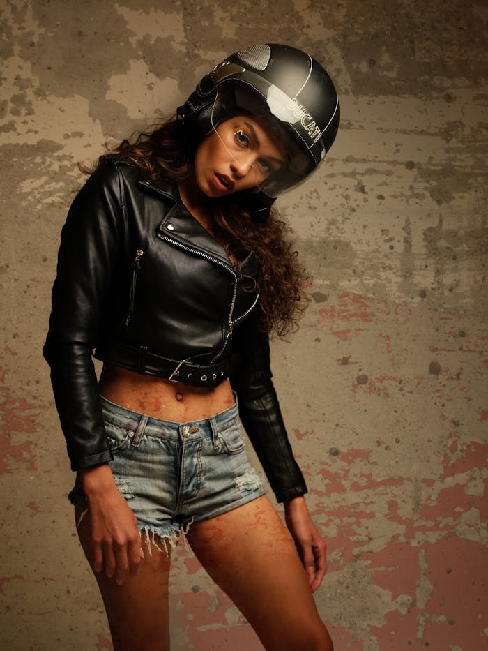 Stylish portrait of a woman wearing a leather jacket and motorcycle helmet, exuding a cool vibe.